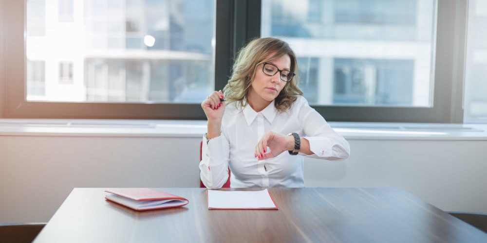 Woman checking watch in meeting room