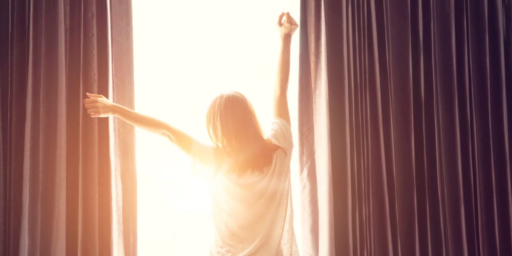 Woman stretching near bed after wake up