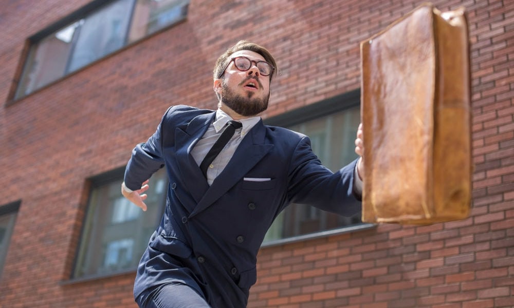 Young businessman running in a city street